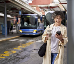 Woman w. Phone next to Bus